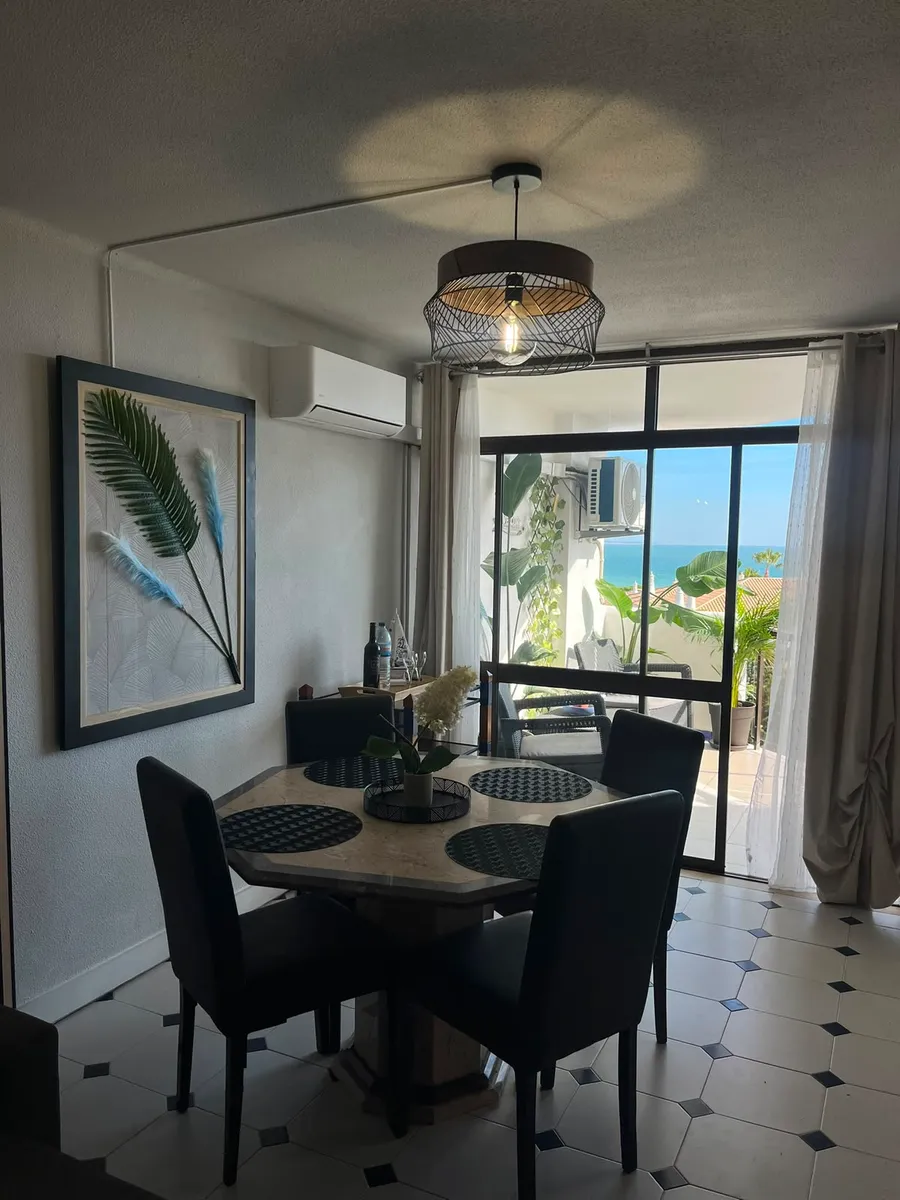Sala de jantar com vista de mar num apartamento gerido
